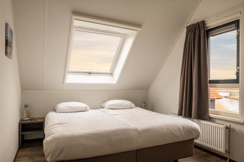 a bedroom with a bed and two windows at Dormio Waterpark Langelille in Langelille