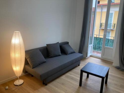 un salon avec un canapé, une table et une lampe dans l'établissement PORT NICE: Very nice 3 rooms, à Nice