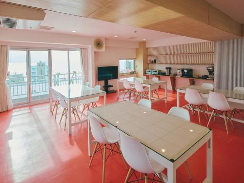 a room with tables and chairs and a kitchen at Guest Living Mu Nanki Shirahama in Shirahama