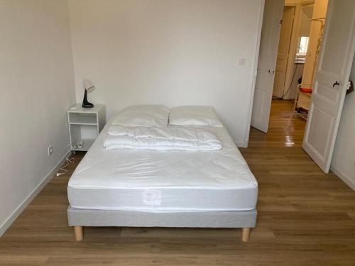 une chambre avec un lit avec des draps blancs dessus dans l'établissement PORT NICE: Very nice 3 rooms, à Nice