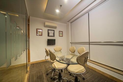 a conference room with a glass table and chairs at Sparrow Hotel Managed by Siara Sariska Alwar in Alwar