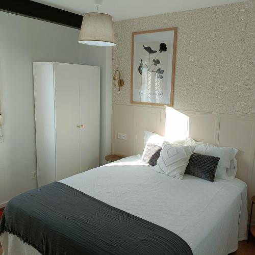 a bedroom with a large white bed with pillows at Curota A in Ribeira