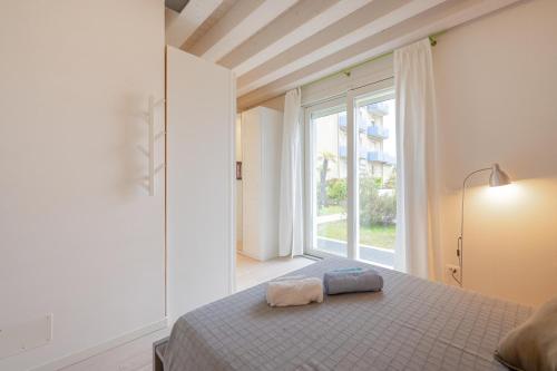 um quarto com uma cama e uma grande janela em Jesolo Beach Villa em Lido di Jesolo