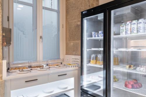 an open refrigerator with food inside of it at Hotel Praza Quintana in Santiago de Compostela