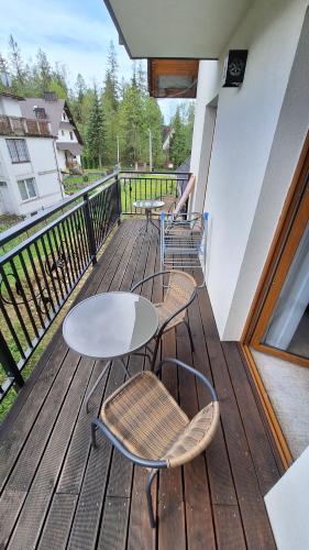 een balkon met 2 tafels en stoelen op een terras bij Willa U Kośle 2 in Zakopane