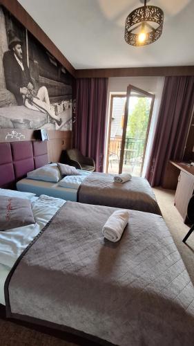 a hotel room with two beds and a large window at Willa U Kośle 2 in Zakopane