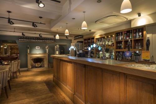 a bar in a pub with a fireplace at The Royal Oak Hotel, Welshpool - The Coaching Inn Group in Welshpool