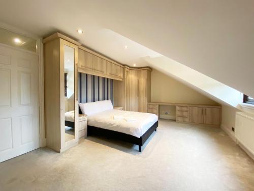 a bedroom with a bed and a staircase at Emerson Park Mansion in Harold Wood