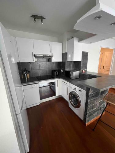 une cuisine avec des placards blancs et un lave-linge. dans l'établissement Beautiful apartment - Centre, à Cagnes-sur-Mer