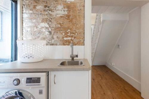 a kitchen with a sink and a washing machine at Stylish house - Moments to Kings Cross & The City in Sydney
