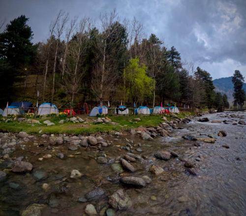 a group of tents next to a river at RIVERFRONT CAMPS AND HIKES in Pahalgām