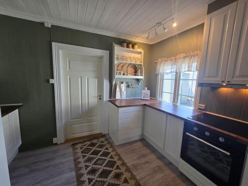 a kitchen with white cabinets and a blue counter top at Cozy Central House in Sandefjord