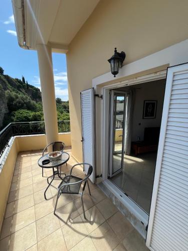 a patio with two chairs and a table on a balcony at Litsa's Central Apartments in Agios Rokkos