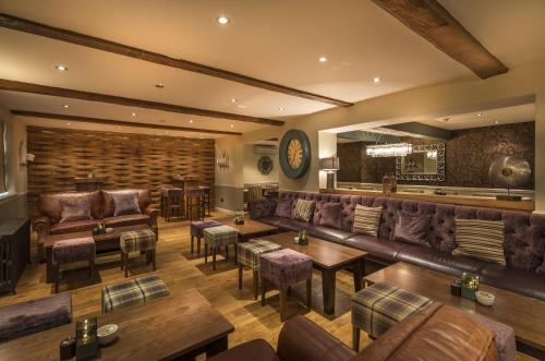 a bar with leather couches and tables and chairs at The Royal Oak Hotel, Welshpool - The Coaching Inn Group in Welshpool