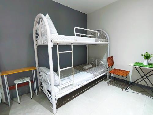 a white bunk bed in a room with a chair at HOST HOMESPACE in Tacloban