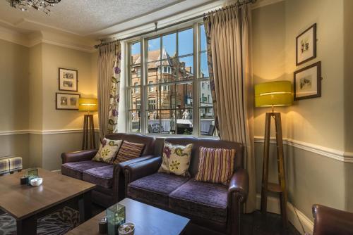 a living room with couches and a large window at The Royal Oak Hotel, Welshpool - The Coaching Inn Group in Welshpool