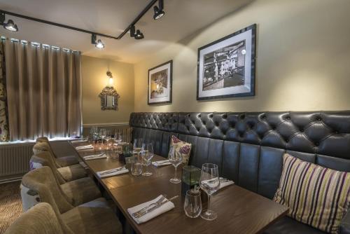 a restaurant with a long table and chairs at The Royal Oak Hotel, Welshpool - The Coaching Inn Group in Welshpool