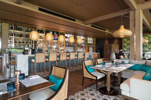 ein Restaurant mit Tisch und Stühlen und einer Bar in der Unterkunft Aquella Lakeside Villas in Thai Muang