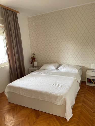 セリネにあるApartments Zaraの白いベッドと壁が備わるベッドルーム1室が備わります。