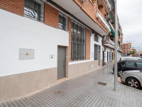 uma rua com um carro estacionado ao lado de um edifício em Apartamentos La Fuensanta em Córdoba