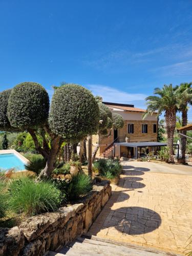 un complexe avec des arbres, une piscine et un bâtiment dans l'établissement Villa Lekythos, à Agrigente