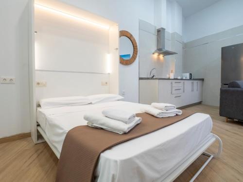 um quarto branco com 2 camas e uma cozinha em Apartamentos La Fuensanta em Córdoba
