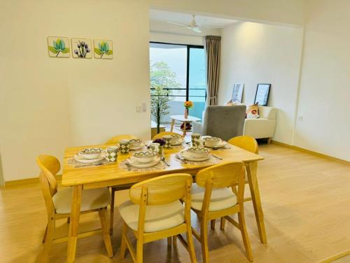 a dining room with a table and chairs and a couch at Mutiara Melaka Beach Resort by Minso in Tangga Batu