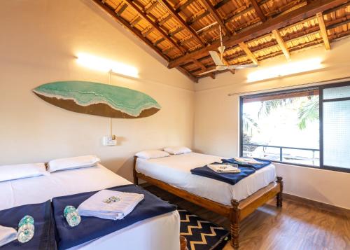 a room with two beds and a large painting on the wall at Sunset Cafe Beach Stay in Gokarna