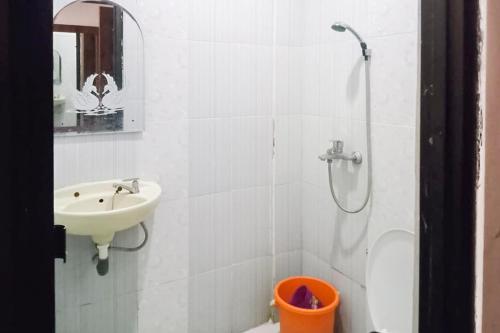 a white bathroom with a sink and a shower at RedDoorz at Pantai Panjang Bengkulu 2 in Bengkulu