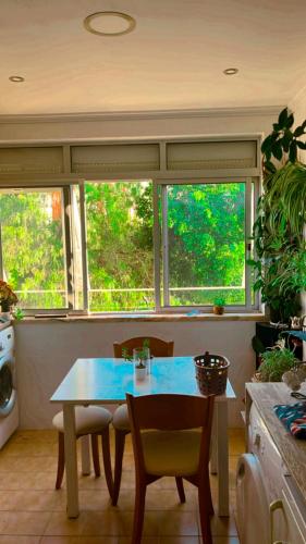 cocina con mesa, sillas y ventanas en Apartamento com boa luz e localização em Lisboa. en Lisboa