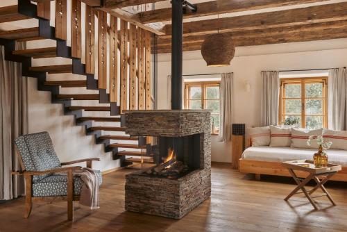 a living room with a fireplace and a staircase at Am Wildbachberg - Luxus Ferienhäuser mit Infinitypool, Privatsauna und Weinkeller in Deutschlandsberg