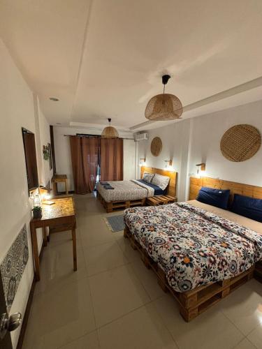 a hotel room with two beds and a couch at La Locanda in Bangkok