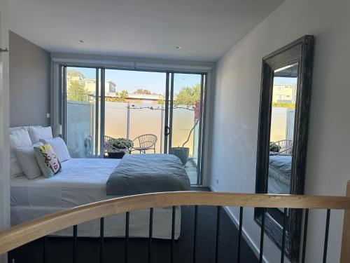 a bedroom with a bed and a balcony with a view at Stylish 2-Bed Terrace with Private Deck in Melbourne