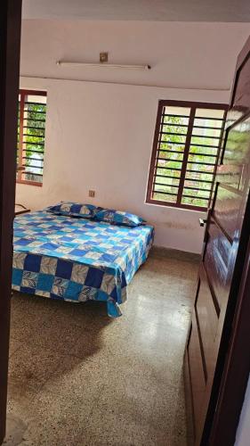 um quarto com uma cama e duas janelas em LMR's Budget Stay em Thrissur
