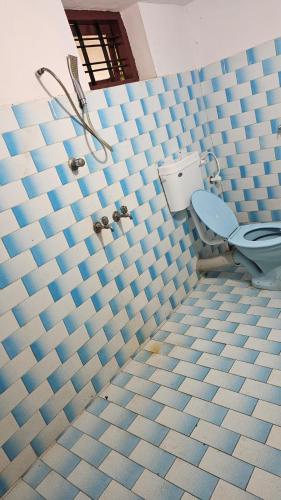 uma casa de banho com azulejos azuis e um WC. em LMR's Budget Stay em Thrissur