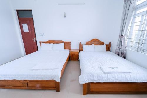2 camas individuales en una habitación con ventana en FGMN HOTEL Pleiku en Plei Brel (2)