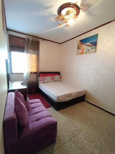 ein Schlafzimmer mit einem Sofa und einem Bett in der Unterkunft Douaa's home in Rabat