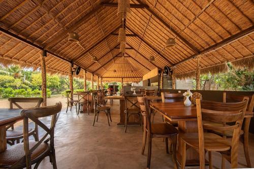 comedor con mesas y sillas de madera en Club Mango Resort en Kalpitiya