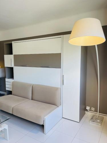 un salon avec un canapé et une lampe dans l'établissement Studio proche centre FARN4, à Cannes