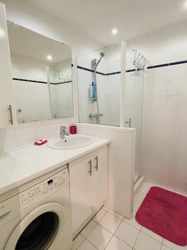 La salle de bains blanche est pourvue d'un lavabo et d'un lave-linge. dans l'établissement Studio proche centre FARN4, à Cannes