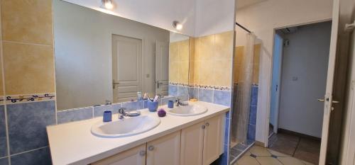 baño con 2 lavabos y espejo grande en La Villa du Golf, en Montboucher-sur-Jabron
