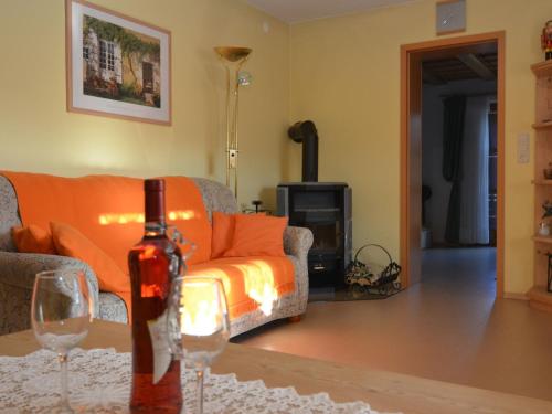 a living room with a couch and two wine glasses at Comfort apartment with balcony in the beautiful Bavarian Forest in Drachselsried