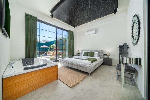 een woonkamer met een bad, een bed en een raam bij Villa Savor in Kas