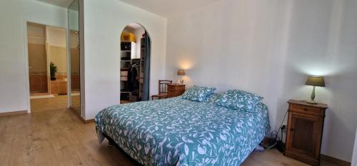1 dormitorio con 1 cama con edredón azul en La Villa du Golf, en Montboucher-sur-Jabron