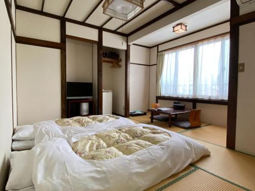 um quarto com uma grande cama branca num quarto em Ryokan Seifuso - Vacation STAY 85475v em Matsumoto