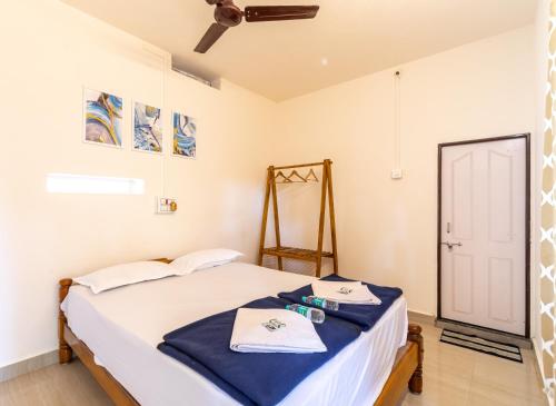 a bedroom with a bed with towels on it at Sunset Cafe Beach Stay in Gokarna
