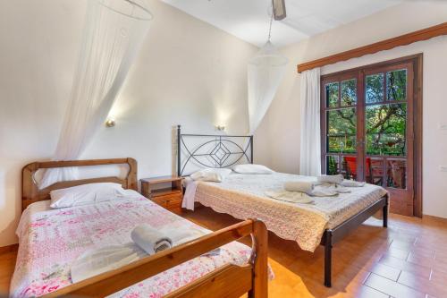 a bedroom with two beds and a window at Castellos Bellos Studio 1 in Marathias