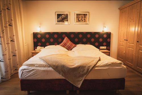 a bedroom with a large bed with two night stands at Gästehaus Einödberg in Mittersill