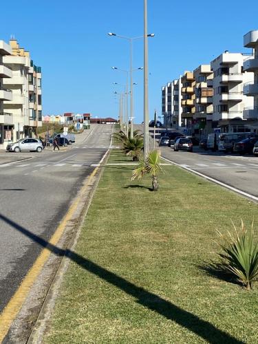 a street with palm trees on the side of the road at Apartamento frente mar in Praia da Vieira