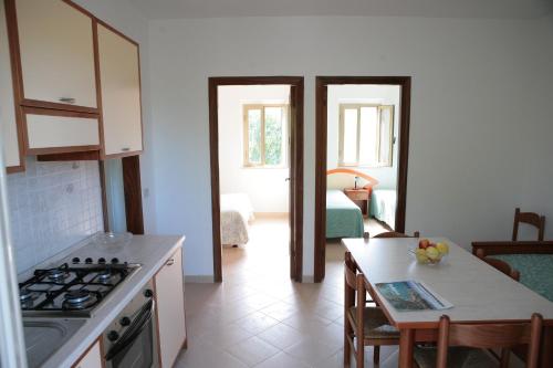una cucina con piano cottura e tavolo in una stanza di Villaggio Bellariva a Peschici